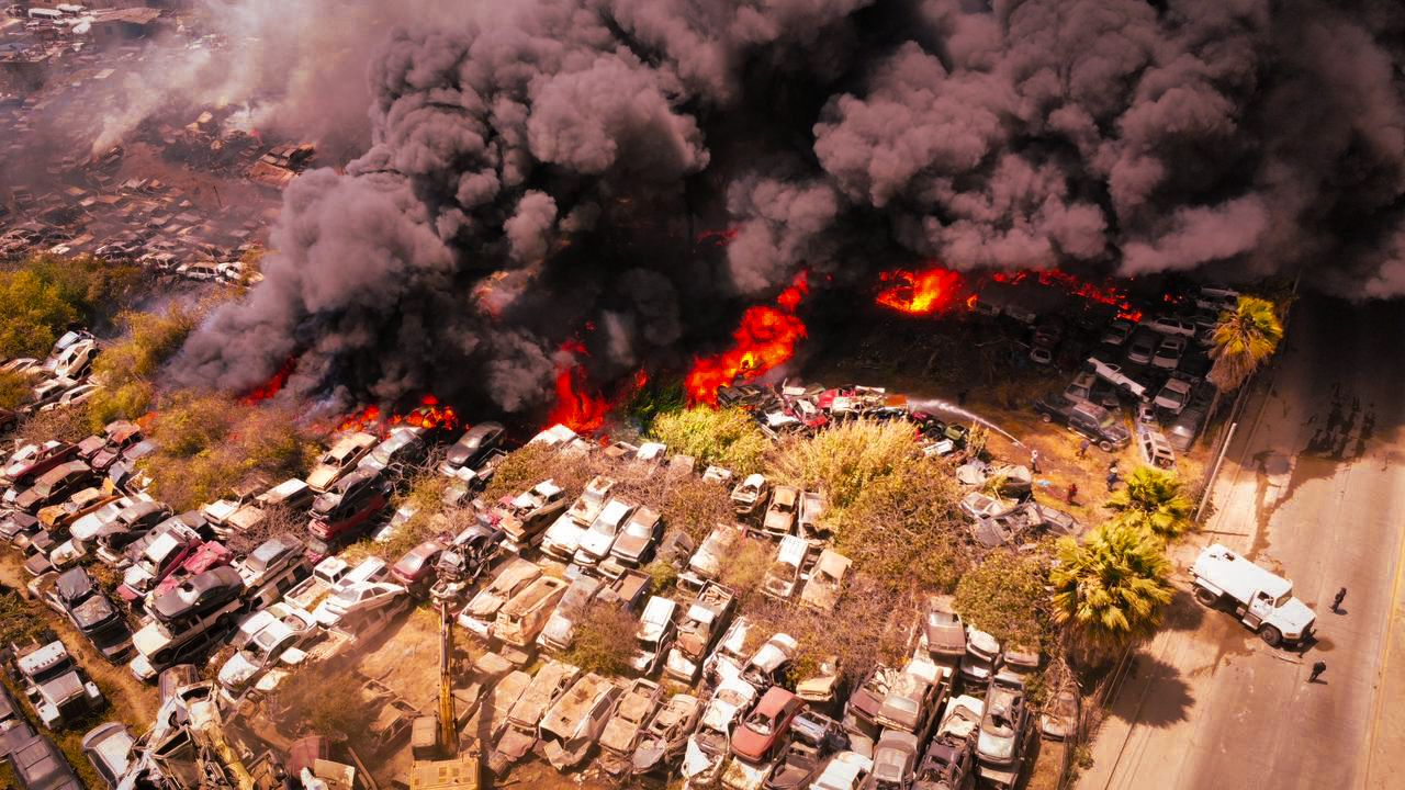 BOMBEROS CONTINÚAN COMBATIENDO INCENDIO EN YONKE DE ENSENADA