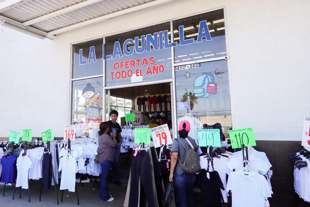 Familias comprando uniformes para el regreso a clases.
